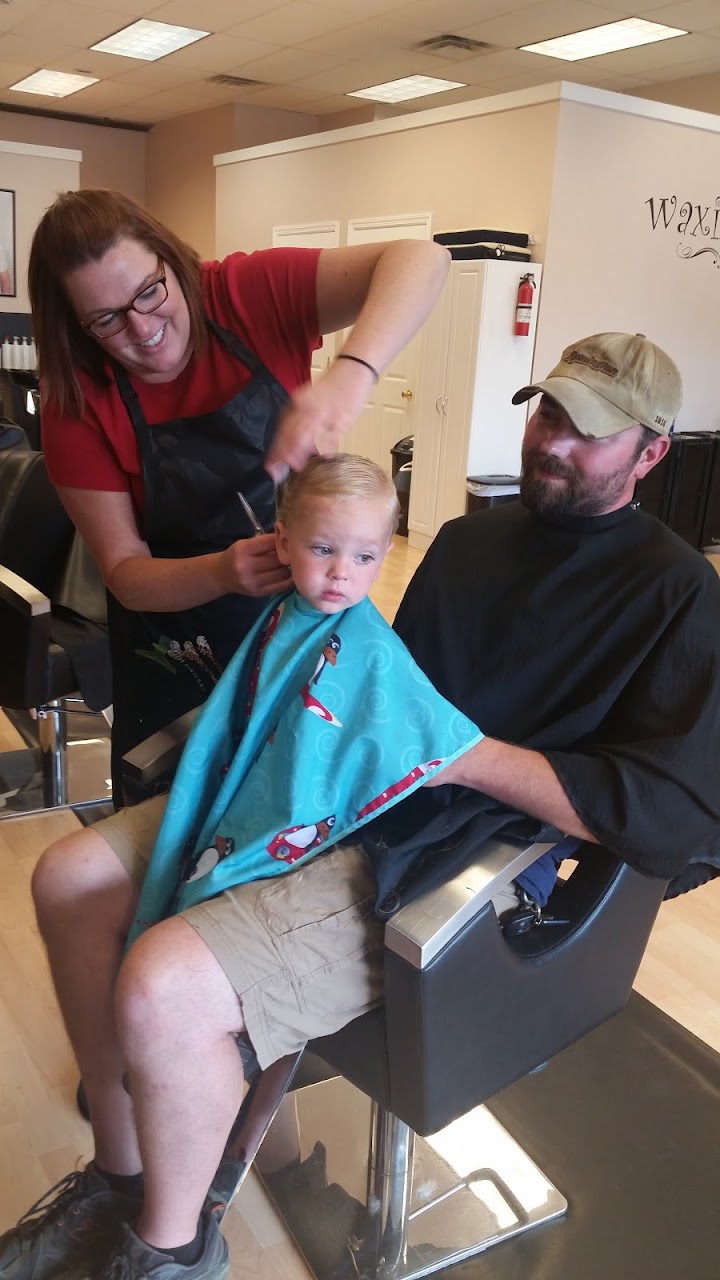 A stylist giving a young child a haircut at Family Cuts & More